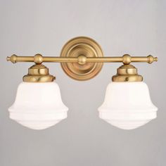 two light brass bathroom fixture with white glass shades