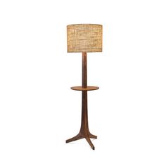 a lamp that is on top of a wooden stand with a light shade over it