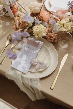 the table is set with flowers and place settings