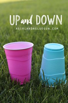 two plastic cups sitting in the grass with text overlay that reads up and down