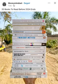 a person holding up a stack of books on top of each other in front of the camera