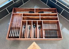 a wooden tray with utensils and spoons in it