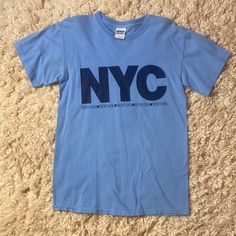 Light Blue T Shirt With Dark Blue Lettering, “Nyc New York”. Large Letters That Read “Nyc” And The Line Below Says New York 5 Times With Apples In Between. Bought In New York City. Excellent Condition, Size Small. All Items Purchased From My Closet Will Be Shipped With Free Gifts! These Could Include Jewelry, Pins, Stickers, Accessories, Hats, Clothes, Bags, Etc. I Try To Tailor The Freebies To The Brand/Style Of The Item Purchased To Make Each Order Seem Like A Mystery Box! :) These Items Range Urban Style Blue T-shirt With Screen Print, Blue Pre-shrunk T-shirt For Everyday, Urban Blue Tops With Text Print, Urban Blue Screen Print Tops, Blue Urban Crew Neck Tops, Urban Blue Crew Neck Top, Basic Blue Tops With Screen Print, Basic Blue Tops With Text Print, Blue Screen Print Top For Everyday