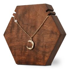 a wooden box with a gold necklace on it and a chain hanging from the front