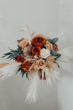 a bridal bouquet with feathers and flowers