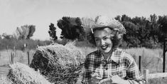 an old black and white photo of a woman with hay