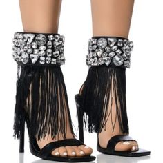 The Azalea Wang " The Rhinestone Draped Tassel Sandal " In Black Is An Open Square Toe Sandal Featuring A Faux Leather Upper, A Cushioned Faux Leather Midsole, A Slim Toe Band, And A Stiletto Heel. Complete With A Wide Rhinestone Gemstone-Embellished Ankle Band, Tassel Fringe Detailing, And An Easy-Open Velcro Closure. Accent This Pair With A Silky Slip Dress For A Luxe Look. - Open Square Toe - Stiletto Heel - Faux Leather Upper - 4.75” Heel Height Party Open Toe Sandals With Tassels, Party Sandals With Tassels And Open Toe, Party Tassel Open Toe Heels, High Heel Tassel Party Sandals, Party Heels With Tassels And Open Toe, Party Open Toe Heels With Tassels, High Heel Tassel Sandals For Party, High Heel Sandals With Tassels For Party, Elegant Fringe Heels For Party