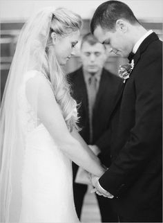 a bride and groom holding hands during their wedding ceremony