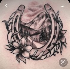 the back of a woman's neck with mountains and flowers on it