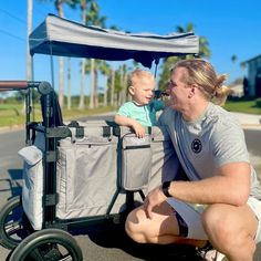 a man sitting next to a baby in a stroller with the words, the keenz xc on it