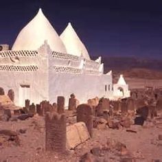 an old building in the middle of a desert with rocks and stones all around it