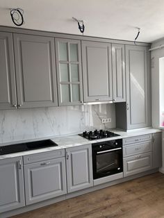 a kitchen with gray cabinets and white counter tops