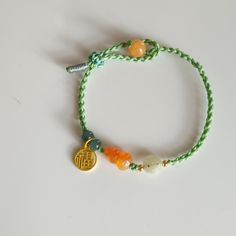 This Bracelet is made of Natural color yellow Jade Gourd. Original color and high quality.  Hand carved Jade Gourd with Jade bead and 14 k Gold filled Good Luck Fu ( 福）hanging on the Bracelet. One side made two Green Donut beads. Hand made beautiful knot with Green color string and it's a adjustable.  Gourd size 13*7 mm. Gold Spiritual Braided Bracelet For Good Luck, Gold Braided Bracelet For Good Luck, Handmade Yellow Gold Friendship Bracelet, Adjustable Multicolor Jade Bracelets, Adjustable Yellow Bracelets As Gift, Green Braided Bracelets With Sliding Knot And Round Beads, Adjustable Yellow Bracelets For Gifts, Adjustable Yellow Braided Bracelets As Gift, Yellow Beaded Bracelet With Sliding Knot As Gift