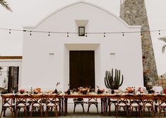 a table set up outside for an outdoor dinner with cactus and succulents