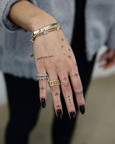 a woman's hand with tattoos on it