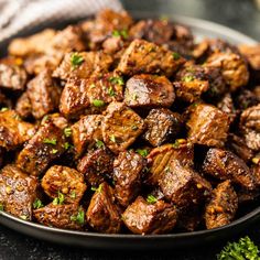 a plate filled with meat and garnished with parsley on the side, ready to be eaten