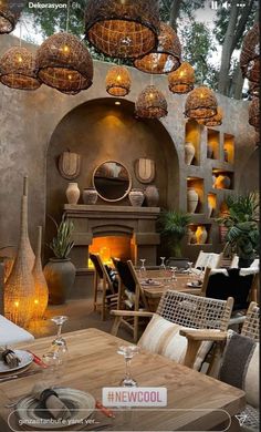 a dining room filled with lots of tables and chairs next to a fire place covered in lights