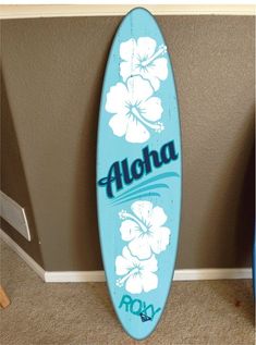 a blue surfboard with the word aloha painted on it is leaning against a wall