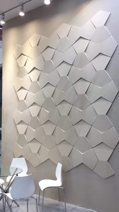 a room with some chairs and a wall made out of hexagonal tiles on it