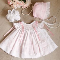 This Little Dress Set Is Most Adorable!! The Set Includes An Heirloom Dress, Slip, Bonnet & Shoes. Smocking, Hand-Embroidery, Satin Ribbons, Pin Tucks And Ruffles Set This Set Apart From The Average Baby Outfit. The Neckline Is Smocked In A Bishop Style And Has Flutter Sleeves That Are Adorned With Pink Dot Embroidery And A Scalloped Embroidered Pink Hem. Embroidered Pink Bullion Buds And Green Leaves Are Super Sweet Atop The Lattice Design Smocking.The Bottom Of The Top Dress Layer Has 8 Row Of Cute White Smocked Dress For Baptism, Cute White Smocked Dress For Daywear, White Smocked Dress With Lace Trim For Daywear, White Lace Trim Smocked Dress For Daywear, Heirloom Bonnet, White Smocked Dress, Baby Pink Clothes, Dot Embroidery, Baby Heirloom