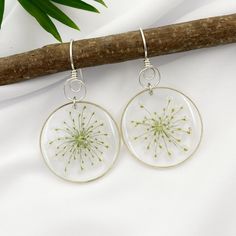 These beautiful real flower dangle earrings are handmade. These white flowers are encased in jewelry grade resin with gold or silver plated bezels, they are simple yet elegant, practically perfect for every day. The flowers have been specially prepared and preserved so that they maintain their beautiful colors. The earrings will be as similar as nature allows, but keep in mind that they are real flowers, so there will always be slight differences. Perfect for that summer wedding, bridesmaid gift Delicate White Earrings With Pressed Flowers, Botanical Style White Birth Flower Jewelry, Silver Pressed Flowers Drop Earrings, Pressed Flowers Sterling Silver Drop Earrings, Sterling Silver Drop Earrings With Pressed Flowers, Sterling Silver Flower Earrings With Pressed Flowers, Dainty White Earrings With Pressed Flowers, Delicate White Jewelry With Natural Inclusions, Dainty White Pressed Flower Earrings