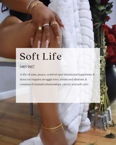 a woman sitting on top of a white chair next to a pile of towels and rings