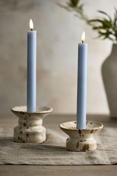 two blue candles sitting on top of a table