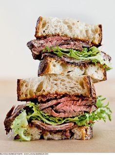 a roast beef sandwich with lettuce and tomato on toasted bread, ready to be eaten