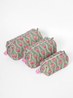 three pieces of green and pink fabric with flowers on the front, two are zippered together