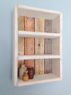 a shelf made out of wood with jars on it