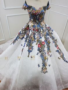 a white dress with blue and red flowers on it