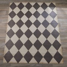 a black and white checkered rug is on the floor in an empty room with hard wood floors