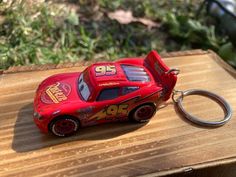 a red car keychain sitting on top of a wooden table