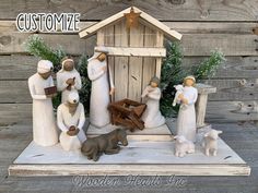 a nativity scene with figurines in front of a wooden hut