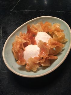 a white bowl filled with food sitting on top of a table next to a black counter