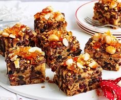 several pieces of dessert on a plate with forks and spoons next to it,