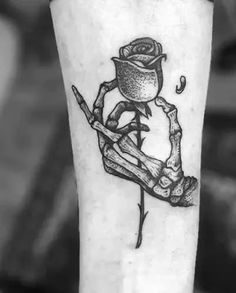 a black and white photo of a rose tattoo on the left leg, with an inking technique