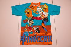 Vintage and rare PINOCCHIO aop all-over-print by Tony & Guy t-shirt. Made in Thailand. It is pre-used and in very good vintage condition. Size on label: Size fit men's M as medium. Please compare your measurements with the measurements provided below before buying this item.   Length from center back: 71 cm / 27.96" inches Chest: 50 cm / 19.69" inches Sleeve Length, from arm opening: 22 cm / 8.66" inches Shoulder to shoulder: 47 cm / 18.50" inches Material: 100% cotton. Condition: very good vint Vintage Cotton T-shirt With All Over Print, Multicolor All Over Print Crew Neck T-shirt, Multicolor All Over Print T-shirt For Fans, Graphic Tee With All Over Print For Fans, Fan Merchandise Cotton T-shirt With All Over Print, Multicolor All Over Print T-shirt For Streetwear, Pop Culture Cotton Tops With All Over Print, Cotton T-shirt With Fan Merchandise Print, Cotton T-shirt With All Over Print For Fans