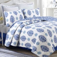 a bed with blue and white bedspread in a room