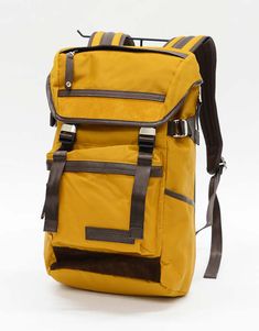 a yellow backpack sitting on top of a white floor next to a black and brown strap