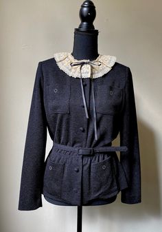 "Unique Leslie Fay black jacket with cream colored needlepoint circle design on pockets and matching belt. Very Wednesday Addams!  Small padding to shoulders. Exquisite lace collar with tie bow. Jacket has alternating covered buttons ands snap closures. Peplum waist. Excellent condition. Fits like a small with the following measurement taken when laying flat: Shoulder to shoulder 16\" Pit to pit 18\" Waist: There is gathered elastic at waist so measures 12\" to 14\" flat." Bow Jacket, Contemporary Clothes, Gothic Lace, White Cotton Blouse, Vintage Gothic, Belted Jacket, Fashion Wishlist, Tie Bow, Wednesday Addams