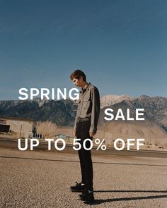 a man standing in the middle of an open field with mountains behind him and text saying spring sale up to 50 % off