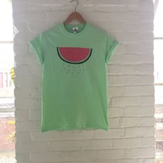 "Hand Printed and Hand Drawn! This is a 100% cotton screen printed t shirt with a hand drawn watermelon. It's perfect for summer! The shirt shown here is mint and is printed in red and green ink. If you are interested in a different color shirt, just message us and ask! // PROCESS: All of our items are individually hand printed by either me or my dad, which can lead to slight variations in placement. The ink is heat cured and will not fade over time. Since our items are printed to order, there i Hand Printed Relaxed Fit Summer Tops, Hand Printed Relaxed Fit Tops For Summer, Trendy Green T-shirt For Summer, Hand Printed Graphic Tee For Summer, Green Graphic Tee For Summer, Green Relaxed Fit T-shirt For Summer, Green Summer Shirt With Funny Print, Green Graphic Print T-shirt For Summer, Hand Printed Crew Neck Tops For Summer