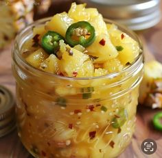 a glass jar filled with macaroni and cheese on top of a wooden table