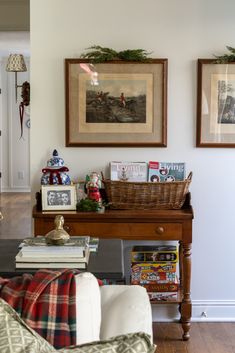 a living room filled with furniture and pictures on the wall next to a coffee table