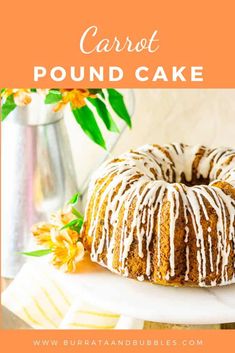 a bundt cake with white icing and flowers on the side, sitting on a plate