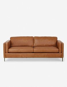 a tan leather couch with metal legs on a white background and no people around it