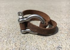 Strap on some style with our Leather Shackle Wrap Bracelet. This unique accessory adds a touch of edgy elegance to any outfit, perfect for those who are both playful and fashion-forward. Wraps around the wrist for a secure fit, making it both stylish and functional. Stainless steel shackle accentuated with brown leather. A great everyday accessory that can be dressed up or dressed down. Handmade Casual Leather Bracelets, Casual Handmade Leather Bracelets, Casual Brown Leather Bracelet, Casual Everyday Bracelet, Adjustable Brown Metal Cuff Bracelet, Adjustable Leather Bracelets With Stainless Steel Clasp, Leather Bracelet With Stainless Steel Clasp For Everyday, Adjustable Bracelet With Stainless Steel Clasp For Everyday Use, Adjustable Casual Cuff Bracelet