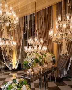 an elegant dining room with chandeliers and flowers