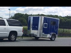 a white truck pulling a blue trailer behind it